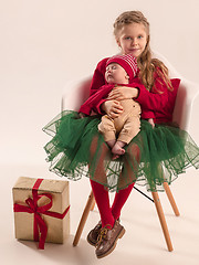 Image showing Happy little teen girl holding his newborn baby little sister. Family love.