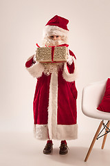 Image showing The happy girl in santa claus costume with gift box at studio