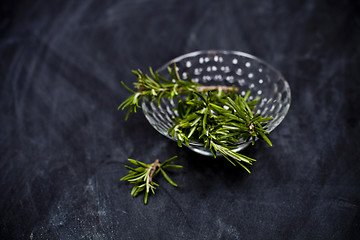 Image showing Fresh rosemary herb in glass bowl.