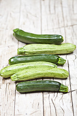 Image showing Fresh green zucchini on wooden rustic table.