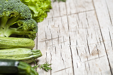 Image showing Variety of green vegetables on rustic wooden background. 