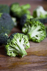 Image showing Fresh green organic broccoli closeup on wooden table.