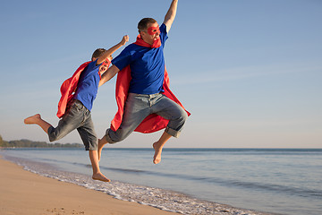 Image showing Father and son playing superhero on the beach at the day time.