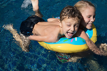 Image showing Two happy children  playing on the swimming pool at the day time