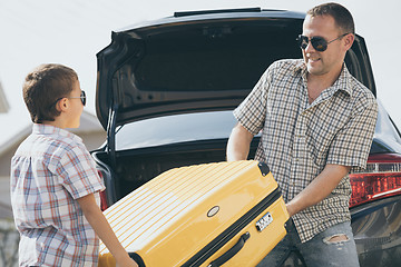 Image showing Happy father and son getting ready for road trip on a sunny day.