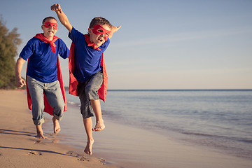 Image showing Father and son playing superhero on the beach at the day time.