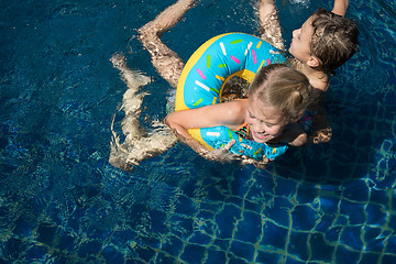 Image showing Two happy children  playing on the swimming pool at the day time