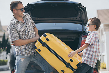 Image showing Happy father and son getting ready for road trip on a sunny day.