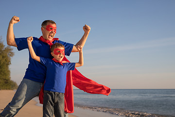 Image showing Father and son playing superhero on the beach at the day time.