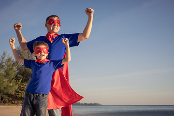 Image showing Father and son playing superhero on the beach at the day time.