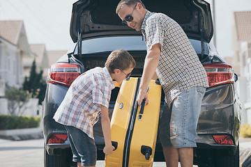 Image showing Happy father and son getting ready for road trip on a sunny day.