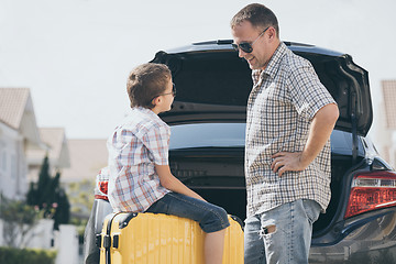 Image showing Happy father and son getting ready for road trip on a sunny day.