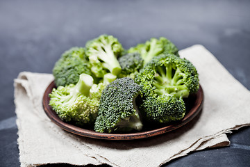 Image showing Fresh green organic broccoli in brown plate and linen napkin