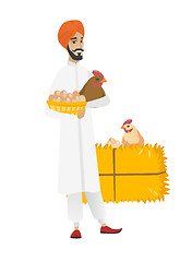 Image showing Farmer holding chicken and basket of eggs.