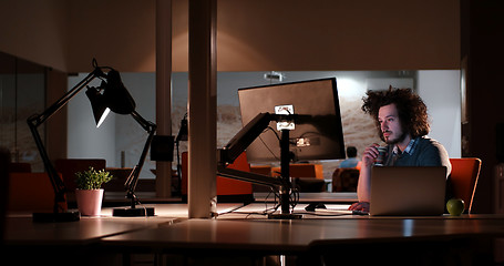 Image showing man working on computer in dark office