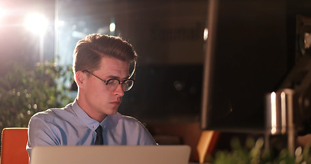 Image showing man working on computer in dark office