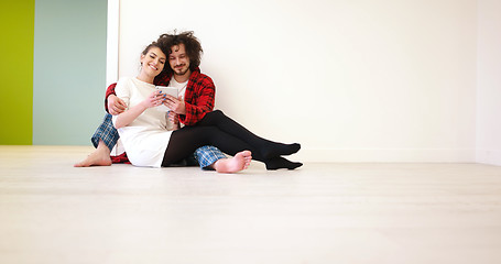 Image showing Young Couple using digital tablet on the floor