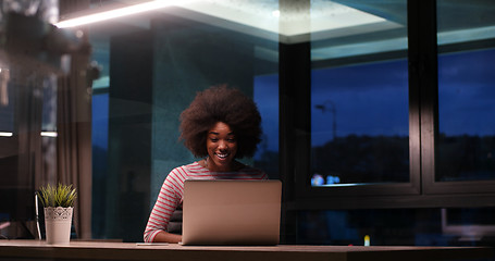 Image showing black businesswoman using a laptop in night startup office