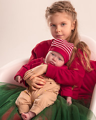 Image showing Happy little teen girl holding his newborn baby little sister. Family love.