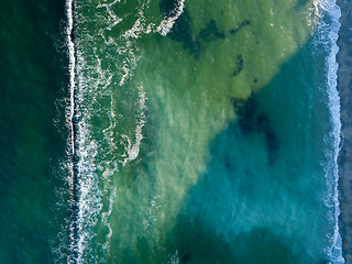 Image showing Ocean waves color of turquoise. Marine natural seascape background. Top view aerial from drone. Copy space.