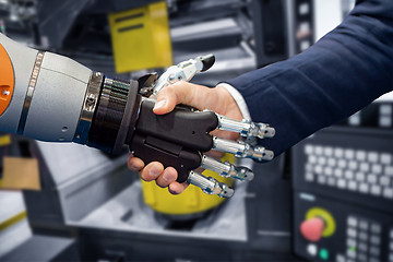 Image showing Hand of a businessman shaking hands with a Android robot.