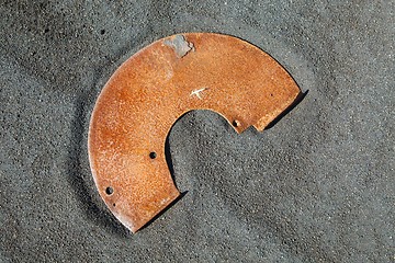 Image showing Rusty metal junk on black sand