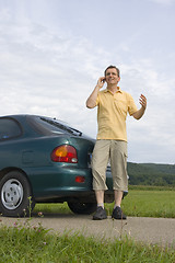 Image showing Man with mobile phone beside his car