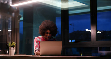 Image showing black businesswoman using a laptop in night startup office