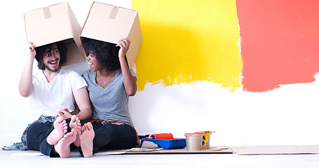 Image showing young multiethnic couple playing with cardboard boxes