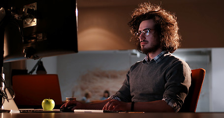 Image showing man working on computer in dark office