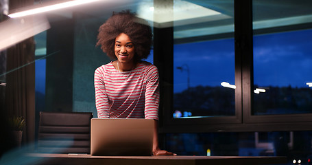 Image showing black businesswoman using a laptop in night startup office