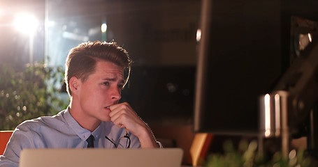 Image showing man working on computer in dark office