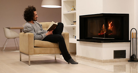 Image showing young man at home reading book