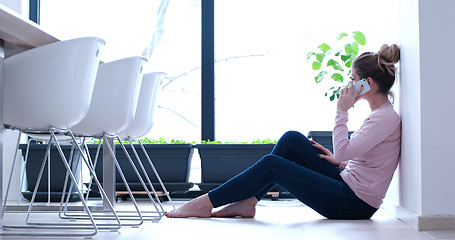 Image showing young women using mobile phone on the floor