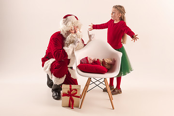 Image showing Christmas portrait of cute little newborn baby girl, dressed in christmas clothes, studio shot, winter time