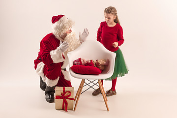 Image showing Christmas portrait of cute little newborn baby girl, dressed in christmas clothes, studio shot, winter time