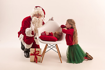 Image showing Christmas portrait of cute little newborn baby girl, dressed in christmas clothes, studio shot, winter time