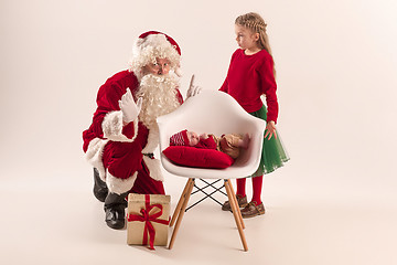 Image showing Christmas portrait of cute little newborn baby girl, dressed in christmas clothes, studio shot, winter time