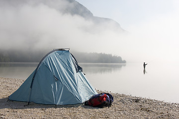 Image showing Fisherman standing in a mountain lake