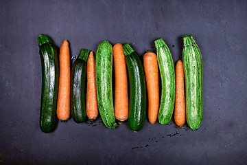 Image showing Fresh organic wet carrots and zucchini on black background. 