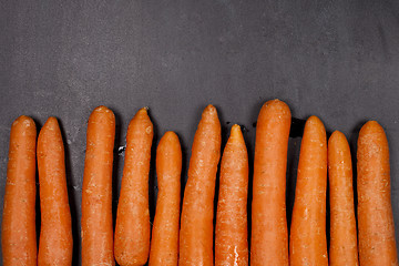 Image showing Fresh organic carrots on black background.