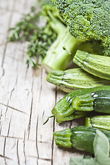 Image showing Variety of green organic vegetables on rustic wooden background.