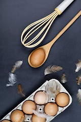 Image showing Eggs, wooden spoon, whisker and feathers.