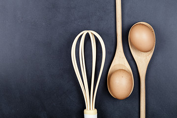 Image showing Eggs, wooden spoon and whisker. 