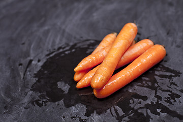 Image showing Fresh organic carrots on black background.