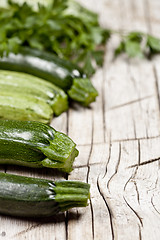 Image showing Variety of green organic vegetables on rustic wooden background.