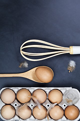 Image showing Eggs, wooden spoon, whisker and feathers. 