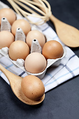 Image showing Eggs and kitchen utensil closeup on backboard background.