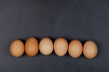 Image showing Six fresh organic chicken eggs on blackboard background.