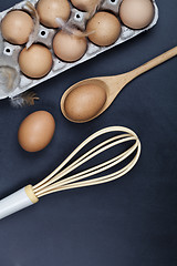 Image showing Eggs, wooden spoon, whisker and feathers. Kitchen utensil for ca